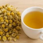 A warm cup of chamomile tea with dried flowers—natural remedy for sleep and digestion.